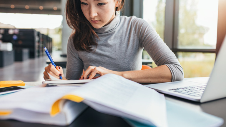 Person working in front of open book with notes